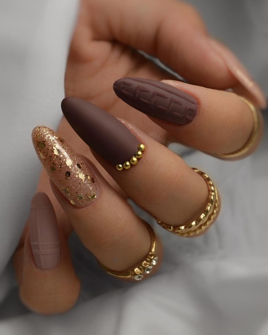 Brown sweater nails with gold glitter.