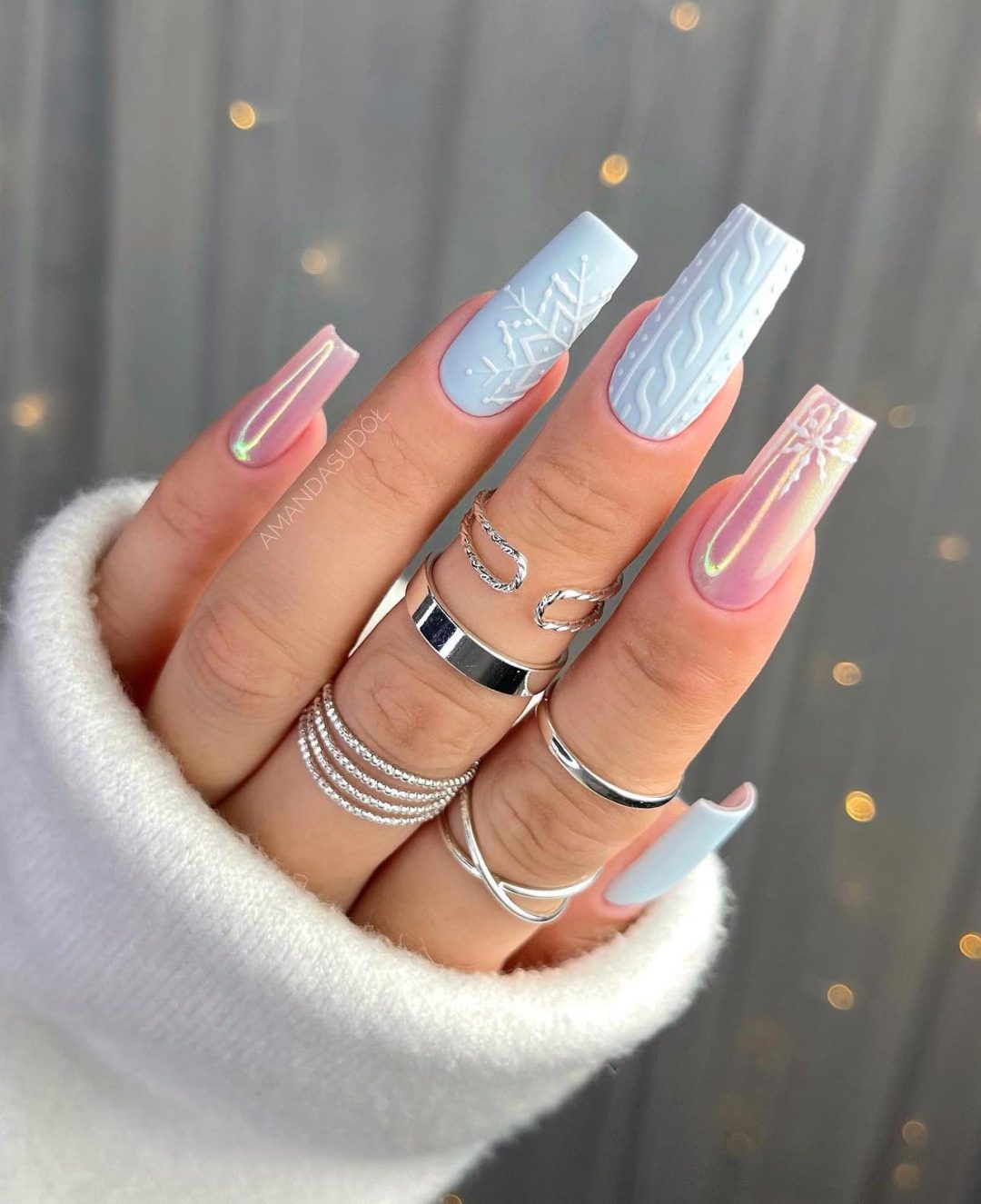 Light blue winter nails with a sweater pattern.