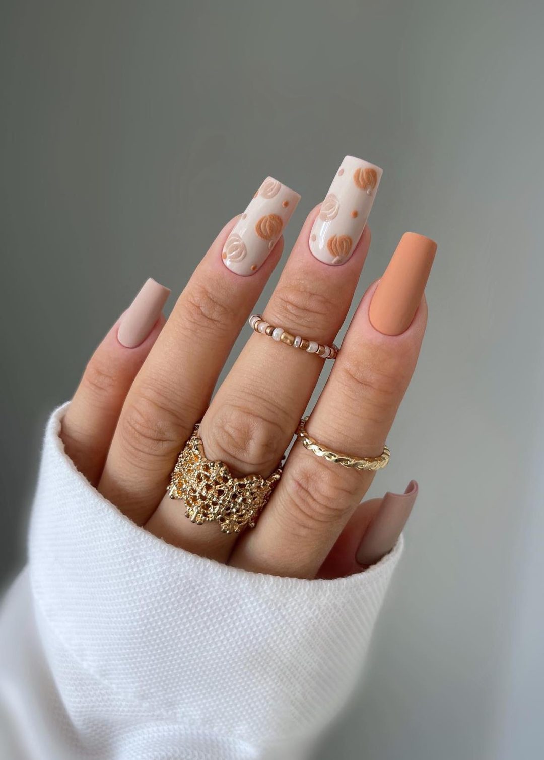 Matte neutral nails with pumpkins.