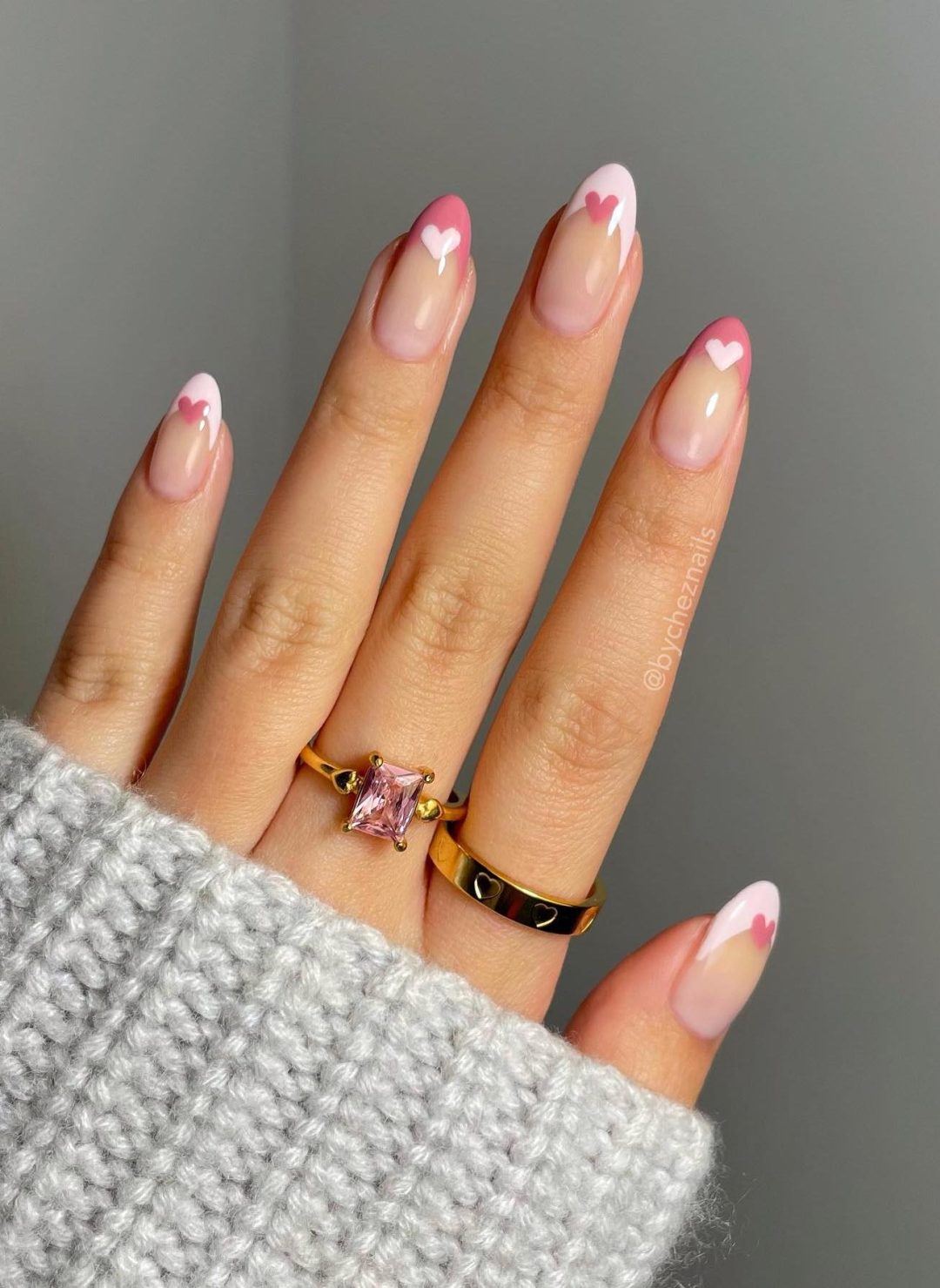 Pink French tip nails with hearts.