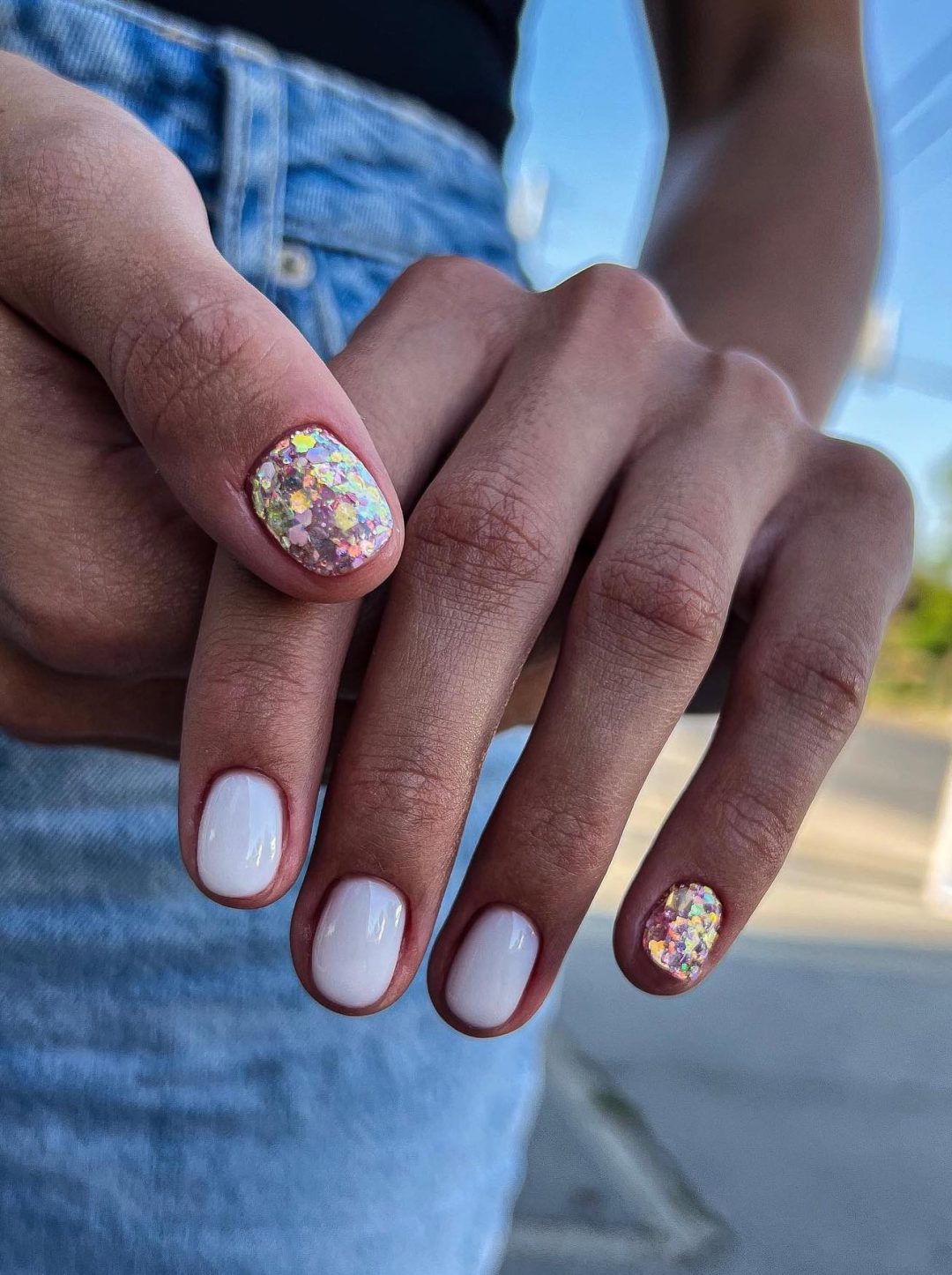 Short milky white nails with gold glitter.