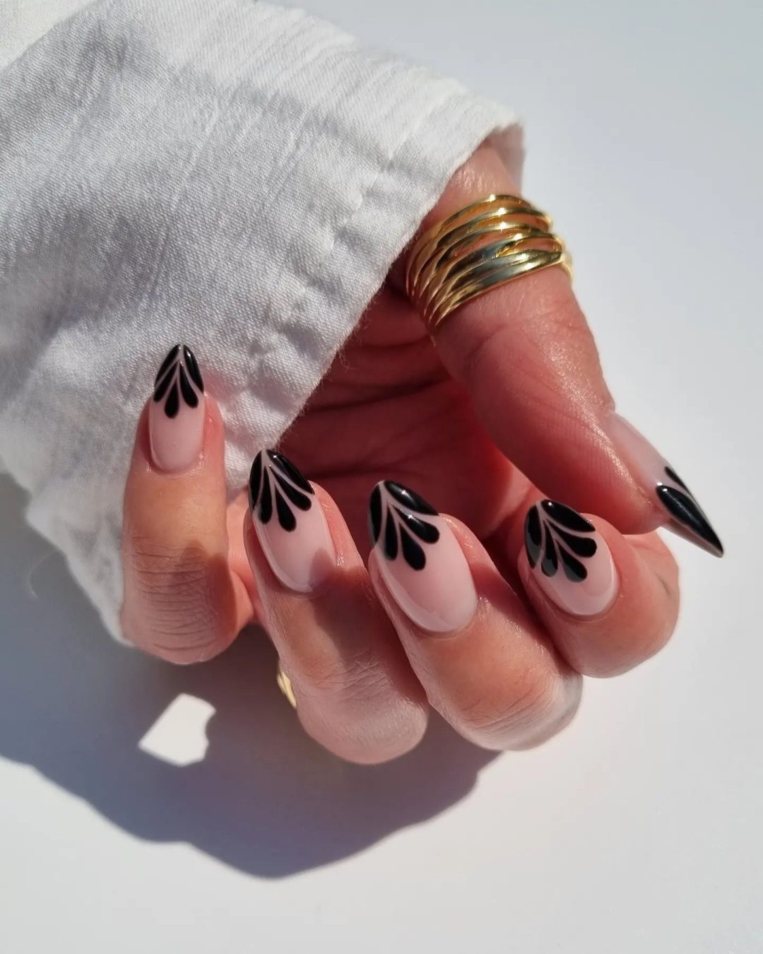 Chic black French tip nails with an abstract design.