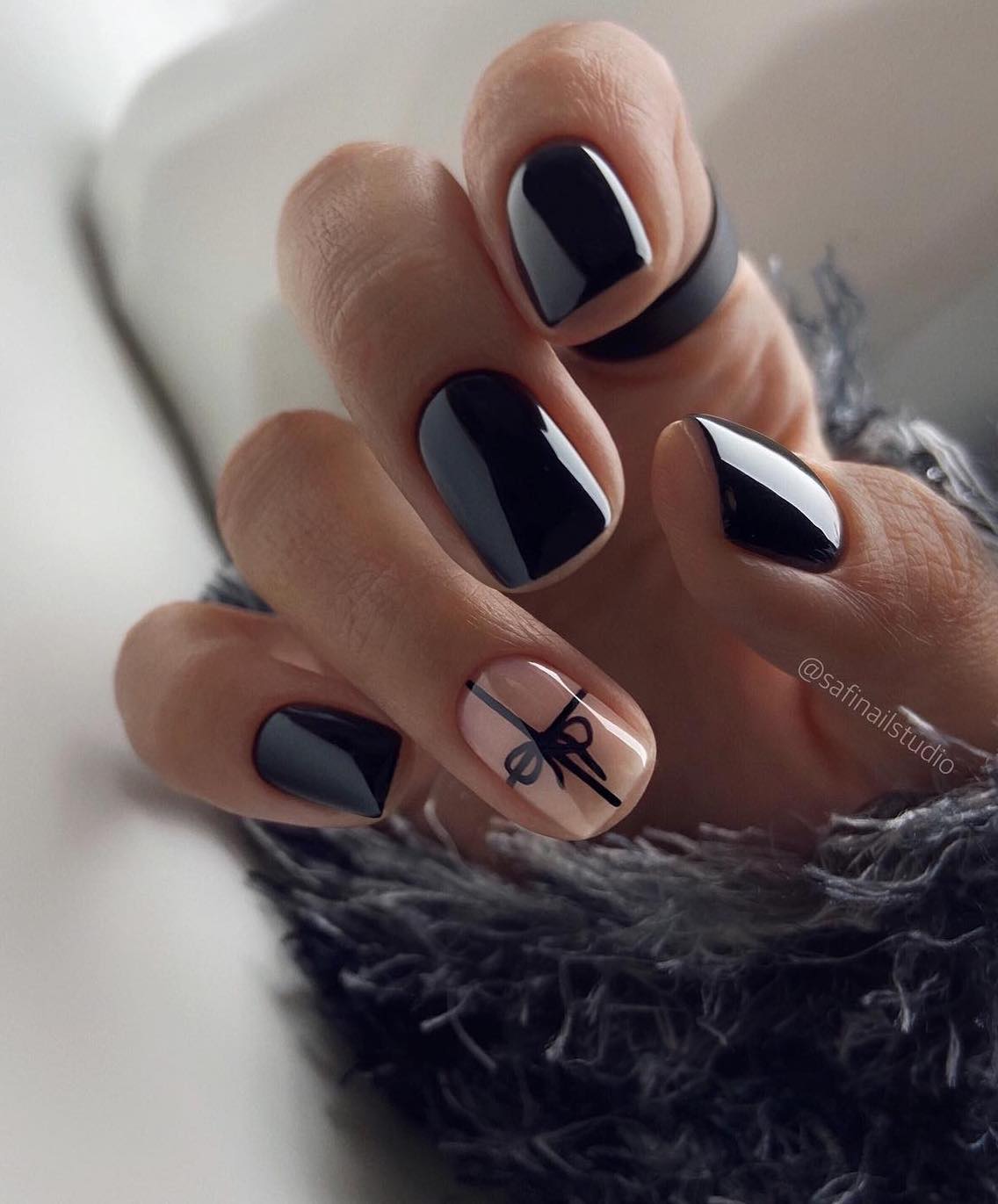 Short black nails with a gift wrap design.