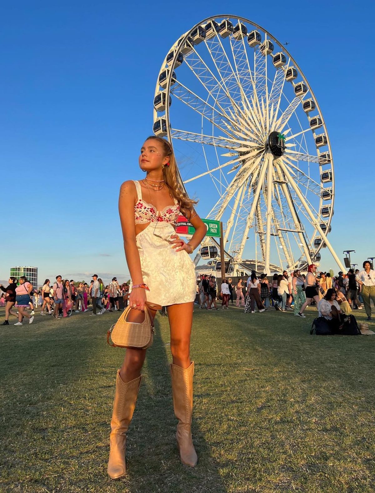 Chic Coachella outfit with white dress and knee high boots.