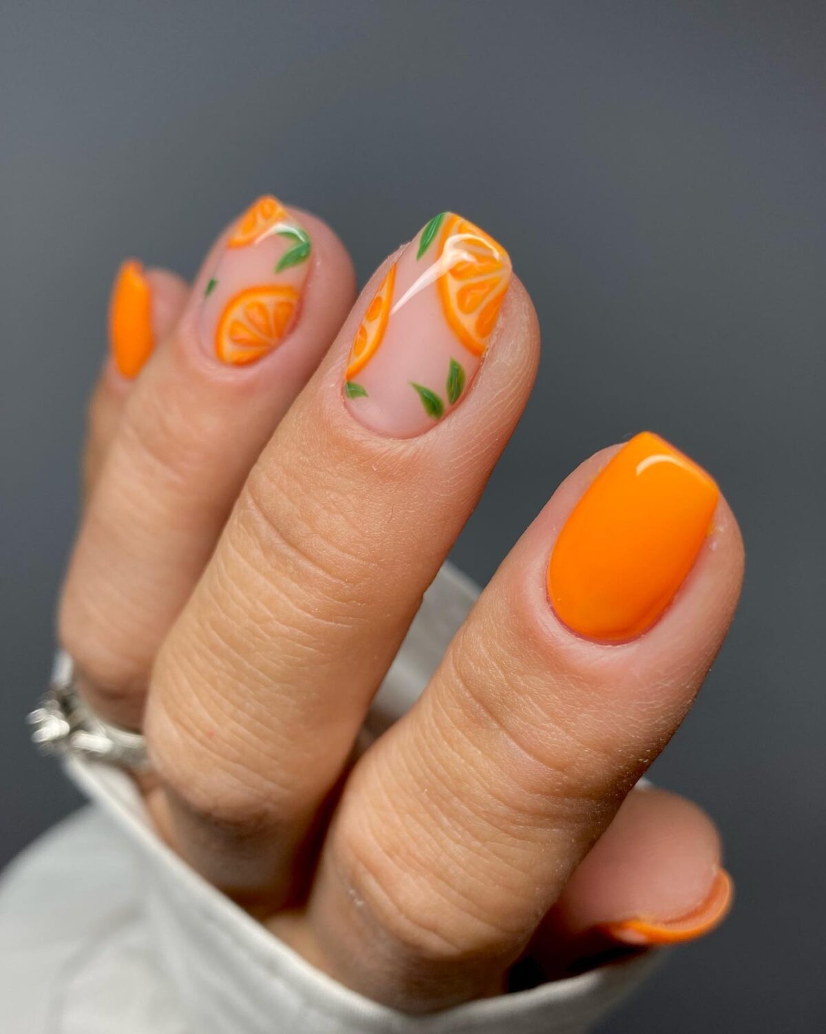 Short orange nails with orange nail art.