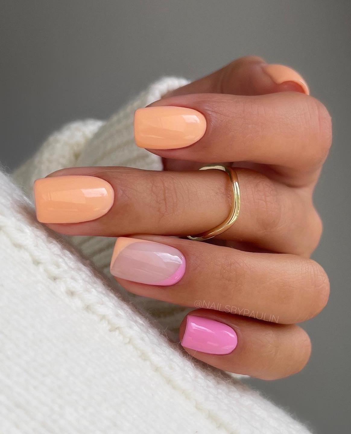 Pastel orange and pink summer nails.