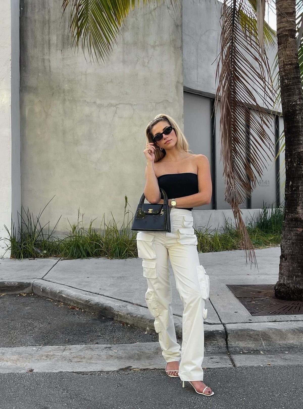 Chic white cargo pants outfit with a black Chanel Kelly bag.