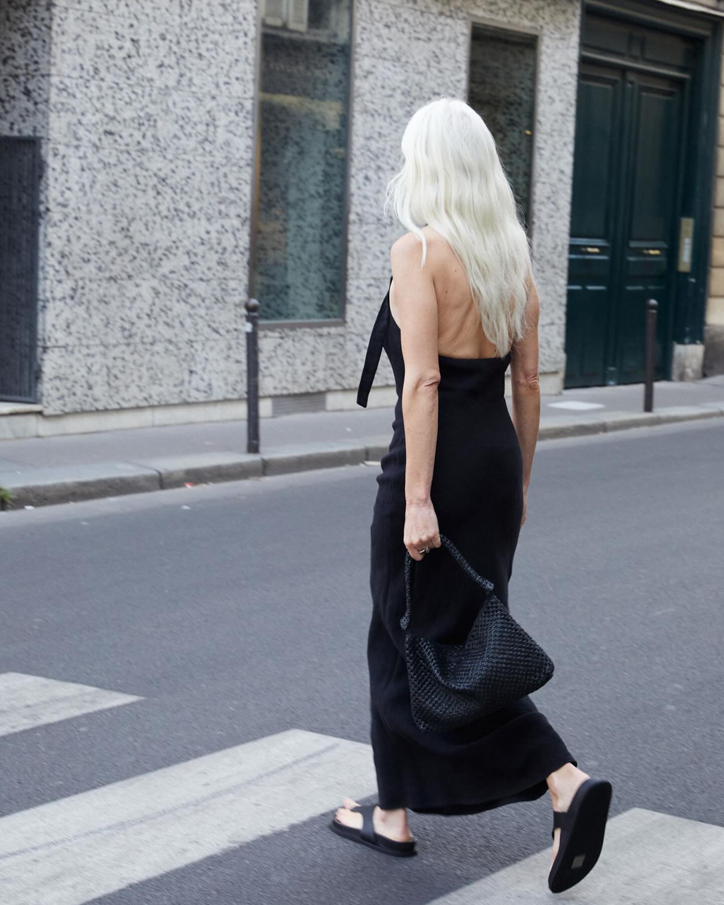 Blonde woman wearing a black maxi dress, black sandals and black flip flops