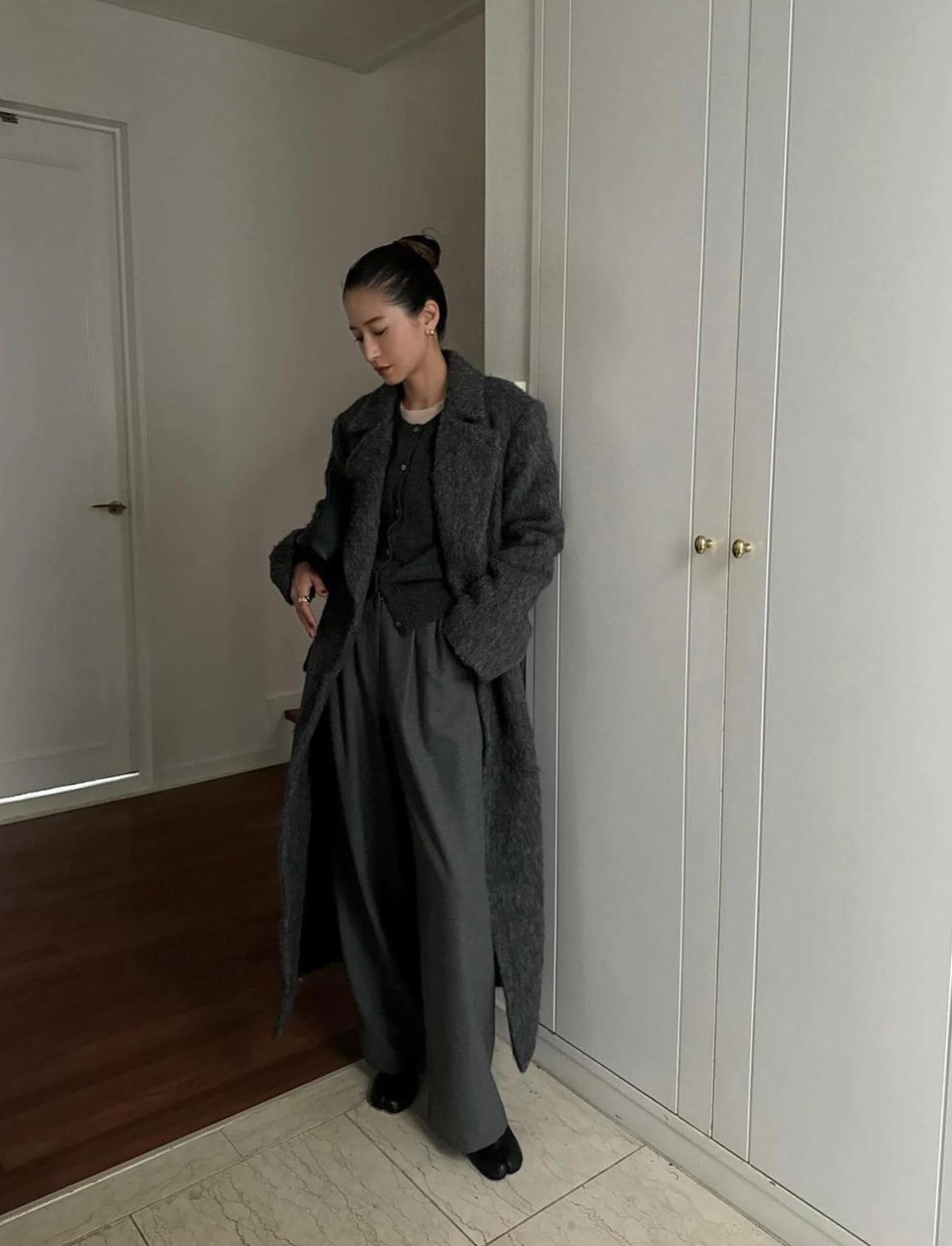 All grey outfit with wide-leg pants and a long coat.