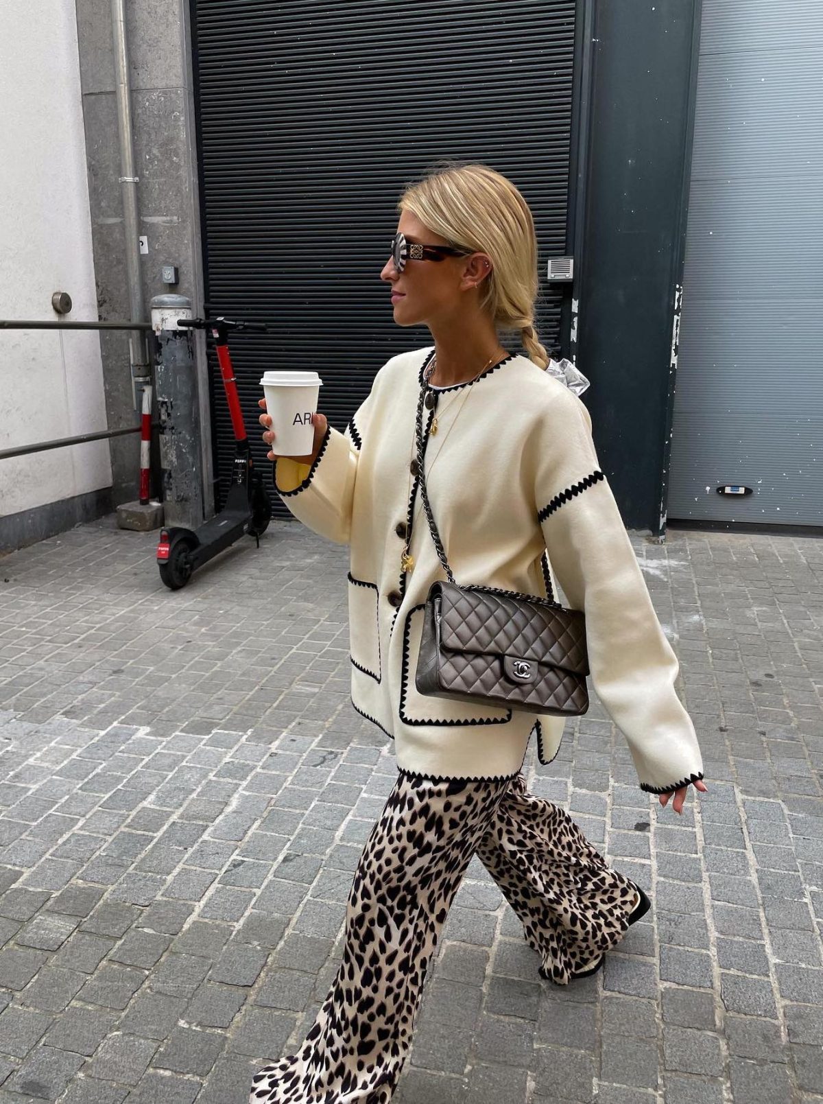 Leopard print pants with a white jacket and silver Chanel bag