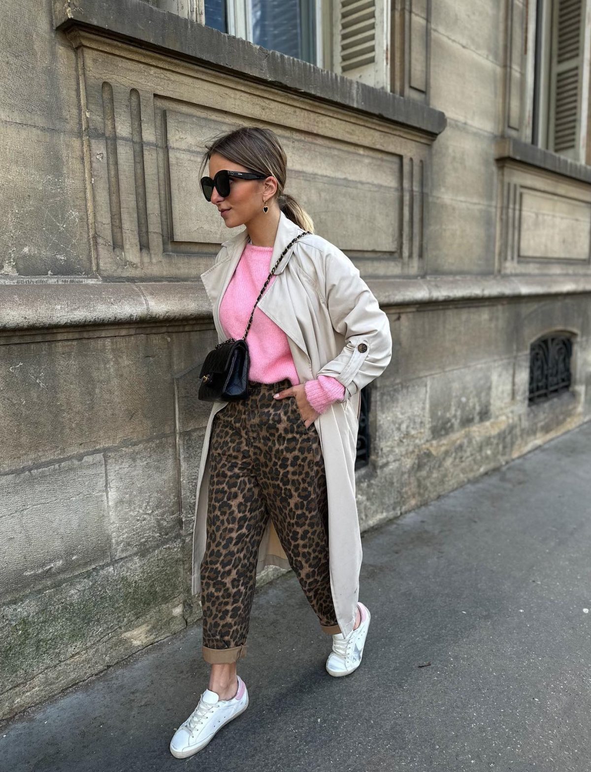 Casual spring outfit with leopard print pants a beige trench coat and a pink sweater