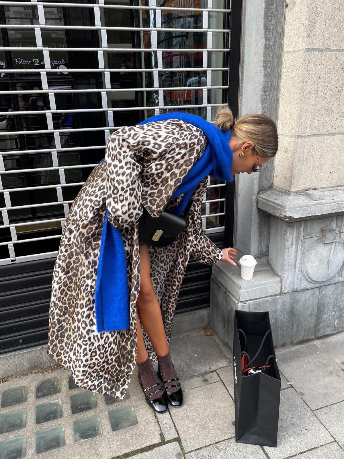 Long leopard print coat with a blue scarf and black Mary Jane flats