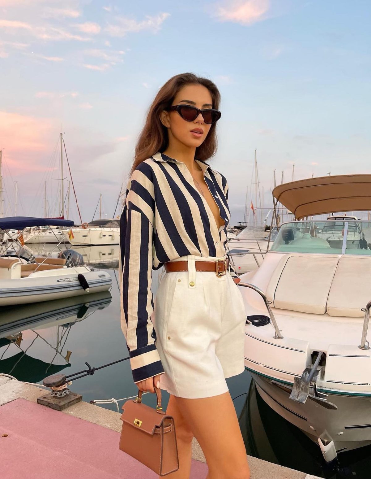 Chic summer outfit with white shorts and a striped button-up linen shirt.