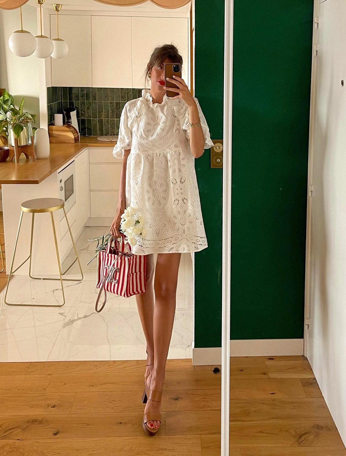 Classy outfit for 4th of July with a short white mini dress and striped red Celine canvas bag.