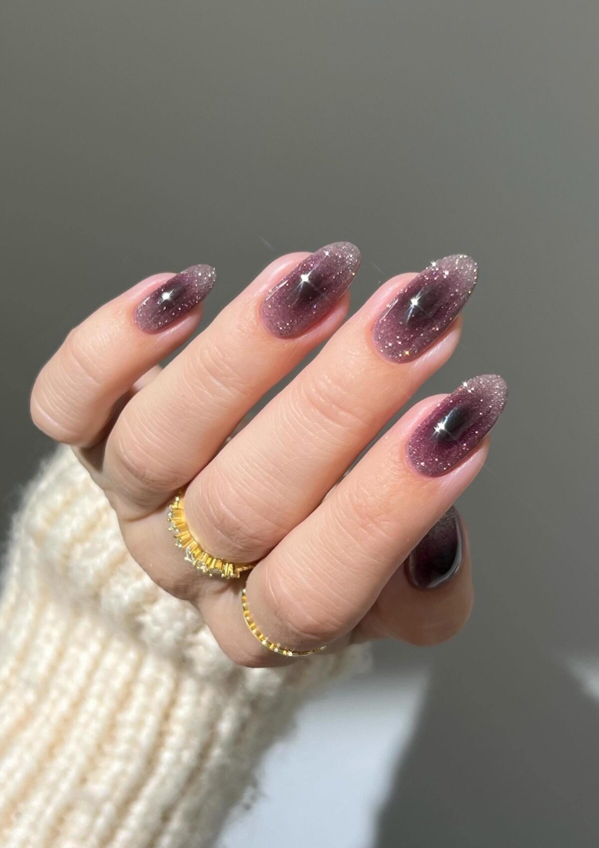 Uñas aura de color morado oscuro con purpurina