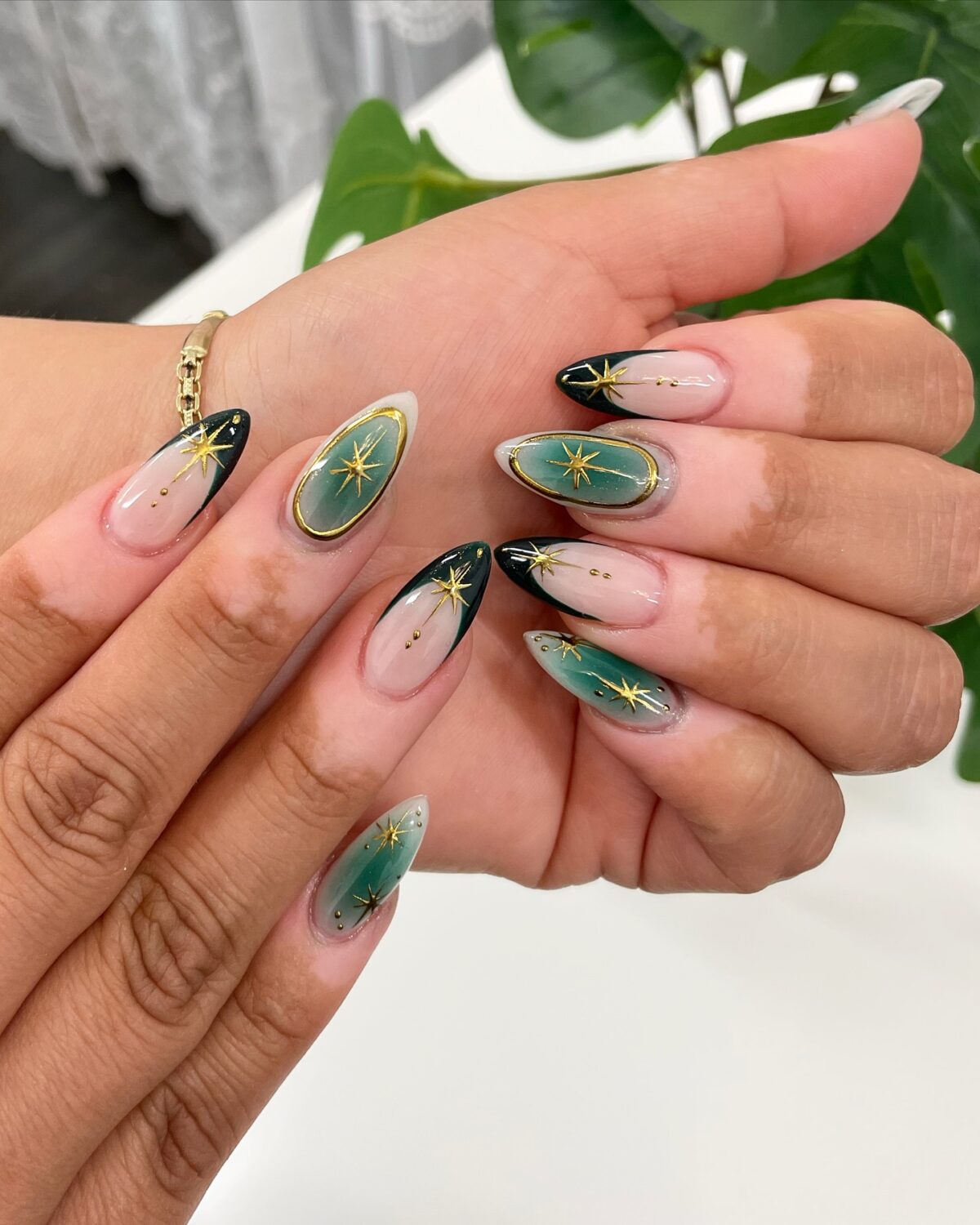 Uñas de aura verde con estrellas doradas